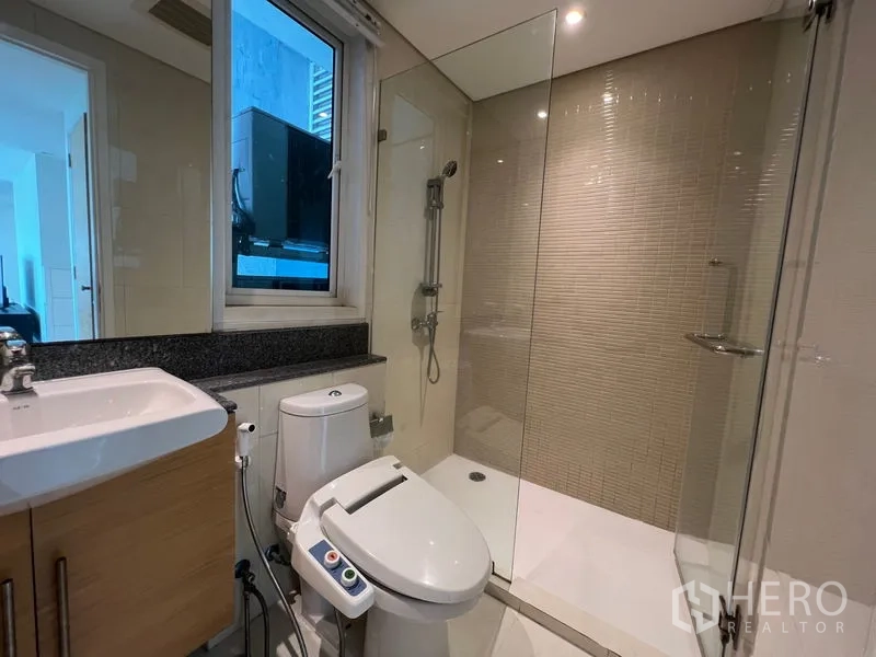Condominium for rent in Watthana, Bangkok - Second bathroom with walk‑in shower, bidet toilet and vanity.