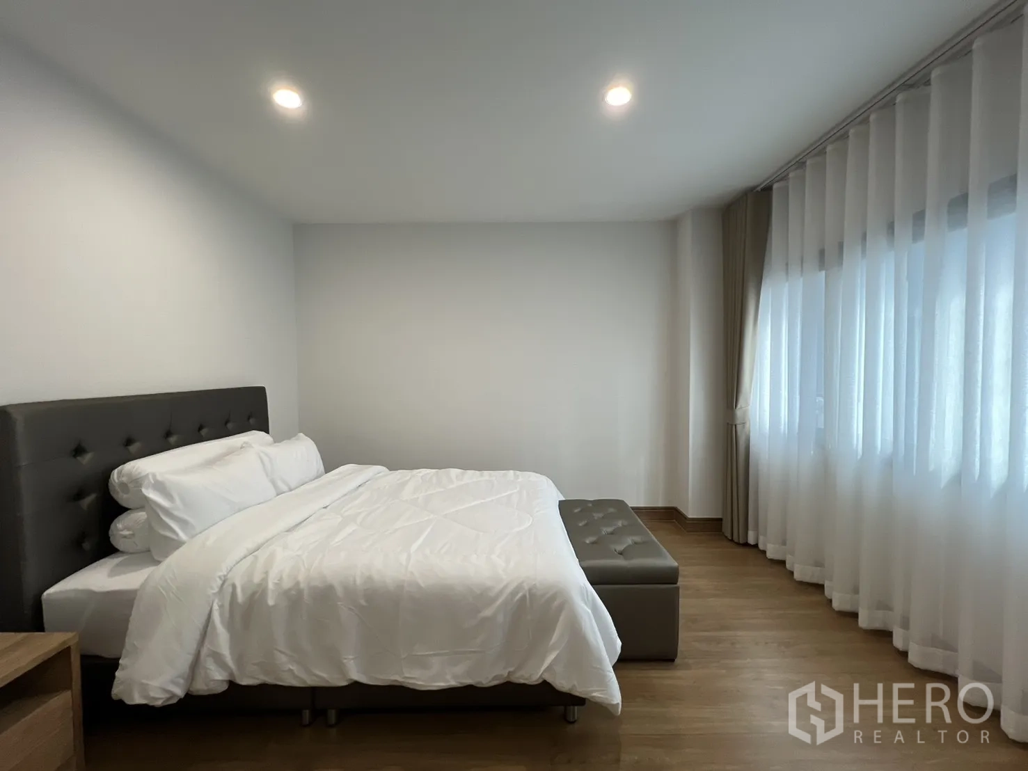 Detached House for rent in Prawet, Bangkok - Bedroom with king bed and wraparound windows for natural light.