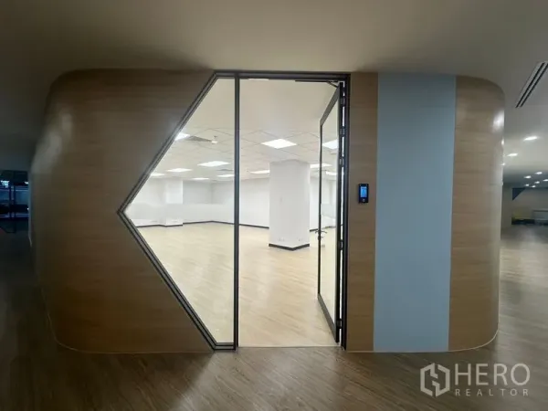 สำนักงาน ให้เช่าในChatuchak, Bangkok - ทางเข้าออฟฟิศสมัยใหม่ด้วยประตูกระจกทรงเรขาคณิตและผนังลายไม้โค้งมน