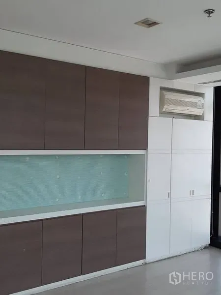 办公空间 出租在Bang Rak, Bangkok - 整面墙的内置柜，带展示格与分体空调。