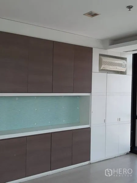 办公空间 出租在Bang Rak, Bangkok - 整面墙的内置柜，带展示格与分体空调。