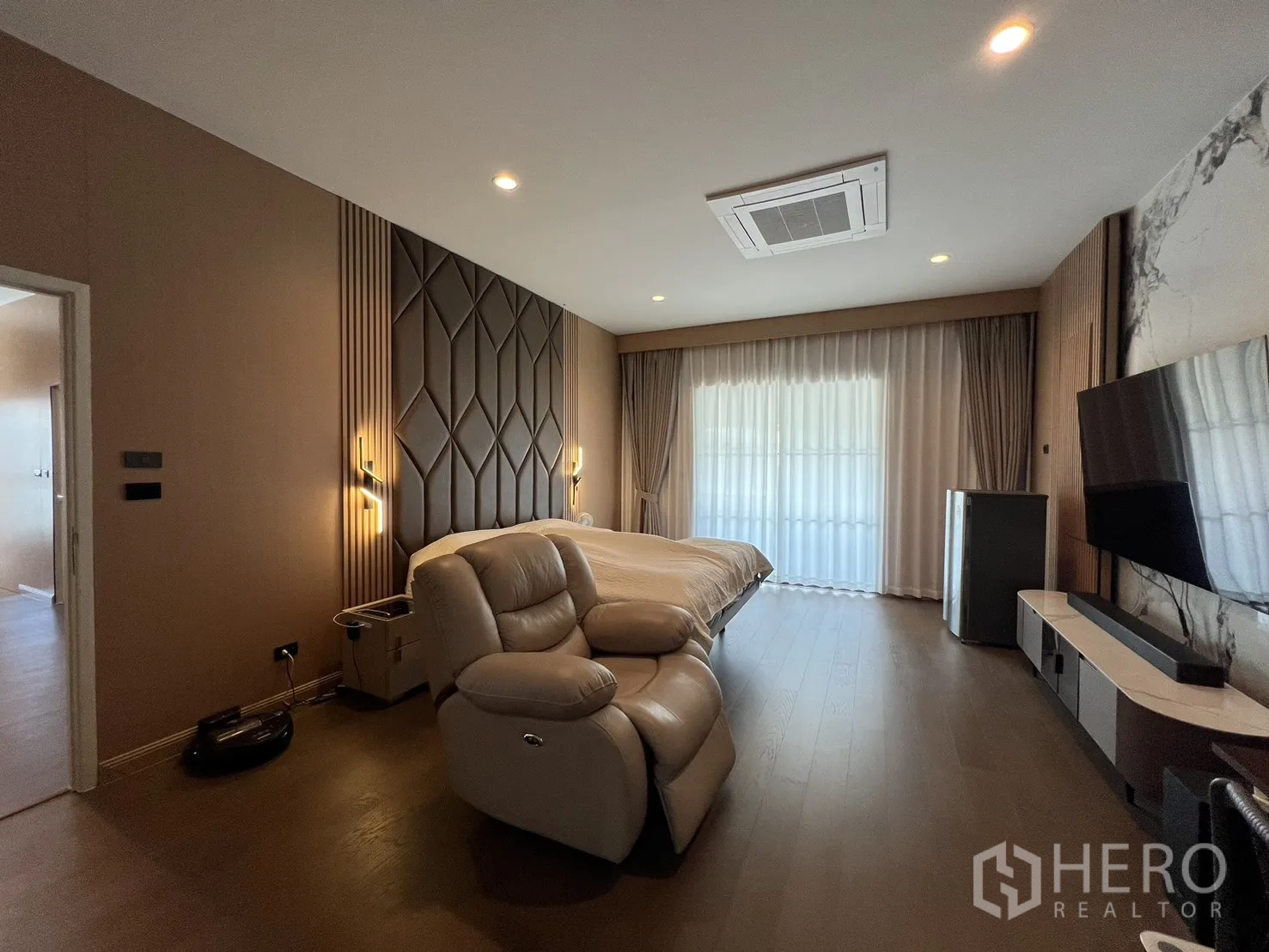 Detached House for rent or sale in Mueang Pathum Thani, Pathum Thani - Master bedroom angle showing feature wall and ceiling cassette air-conditioning.