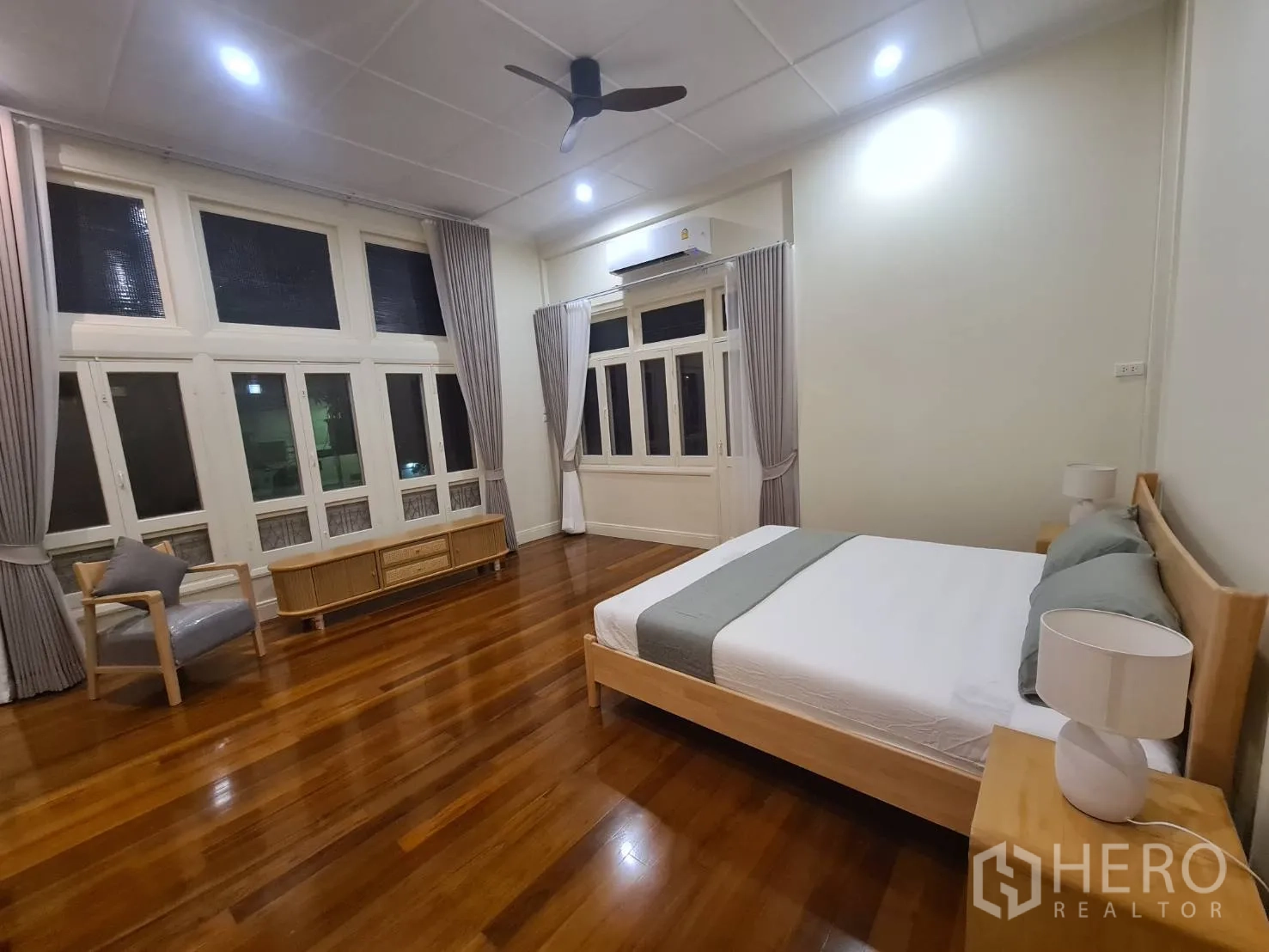 บ้าน ให้เช่าในKhlong Toei, Bangkok - ห้องนอนหลักกว้างหน้าต่างบานใหญ่ พัดลมเพดาน และพื้นไม้เงางาม