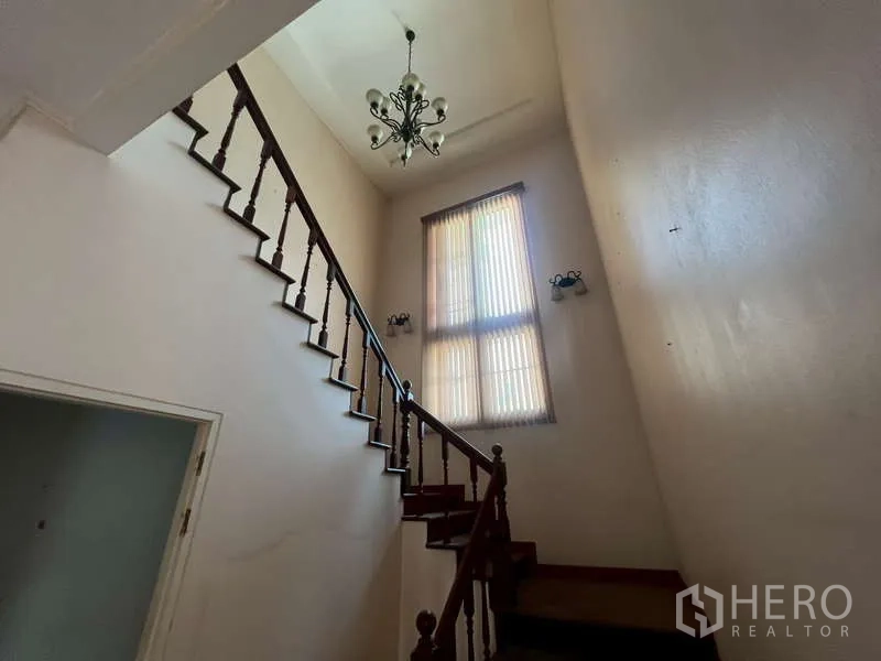 独立式住宅 出租在Watthana, Bangkok - 楼梯配木扶手，高窗与吊灯。