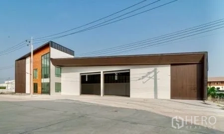 Warehouse for rent in Bang Bo, Samut Prakan - Exterior of the warehouse building with multiple roller shutter bays and a glass-fronted office.