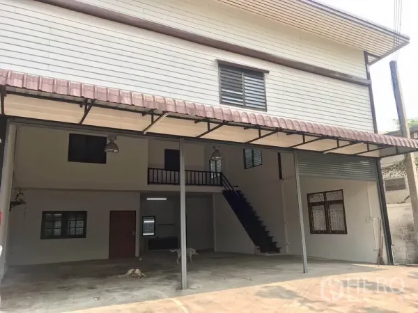 货栈 出租在Pathum Thani - 两层仓库立面，配有金属雨棚与覆盖式装卸区。