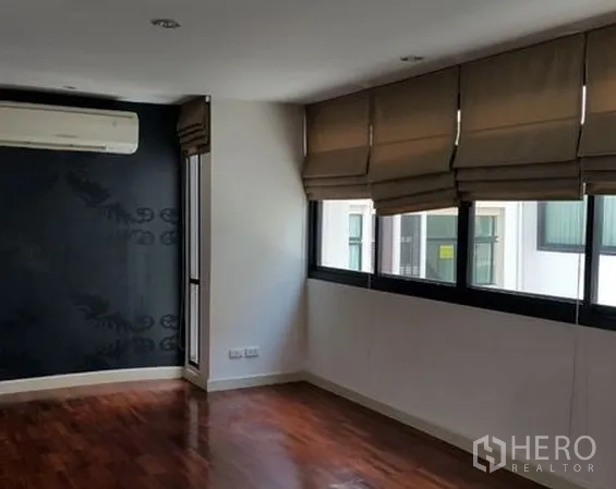 Home Office for sale in Wang Thonglang, Bangkok - Bright upper-floor room with wood flooring, split air conditioner and wide windows with roman blinds.
