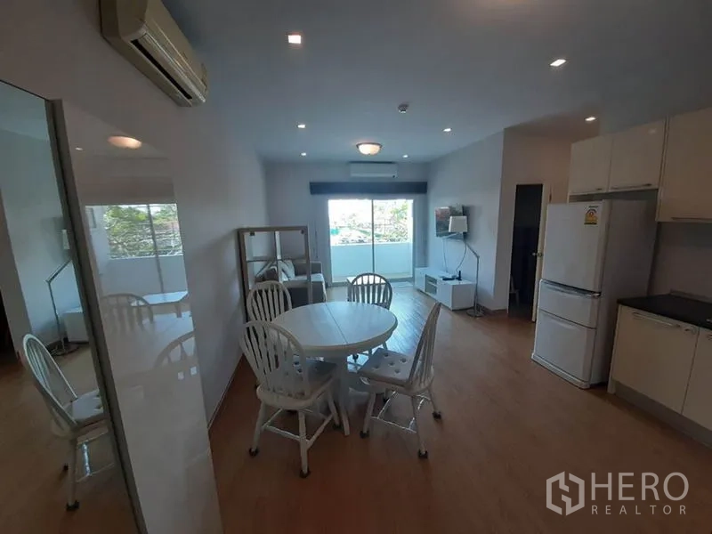 Condominium for sale in Wang Thonglang, Bangkok - Open-plan living and dining area with kitchenette and balcony views.