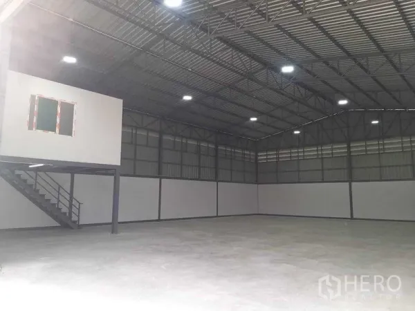 Warehouse for rent in Bang Khun Thian, Bangkok - Spacious high-ceiling warehouse interior with steel truss roof and bright lighting.