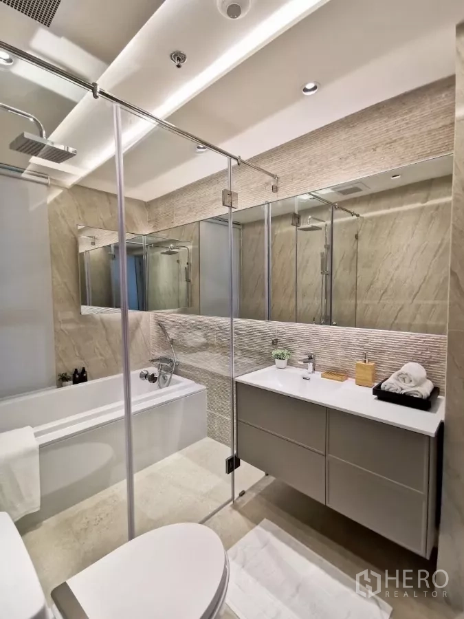 Condominium for rent in Watthana, Bangkok - Contemporary bathroom with glass shower enclosure, rain shower, bathtub and wide vanity mirror.