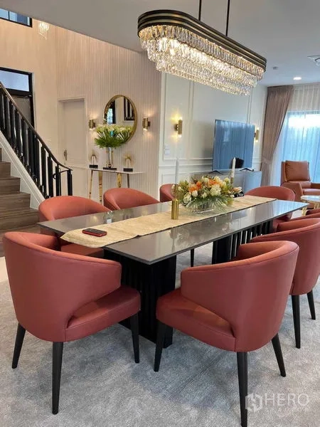 Detached House for rent in Saphan Sung, Bangkok - Elegant dining area with marble-top table, six red chairs, crystal chandelier and staircase view.