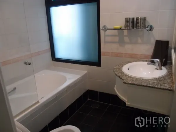 Condominium for rent in Sathon, Bangkok - Clean bathroom featuring a bathtub, granite vanity, and frosted window in a Bangkok condominium.