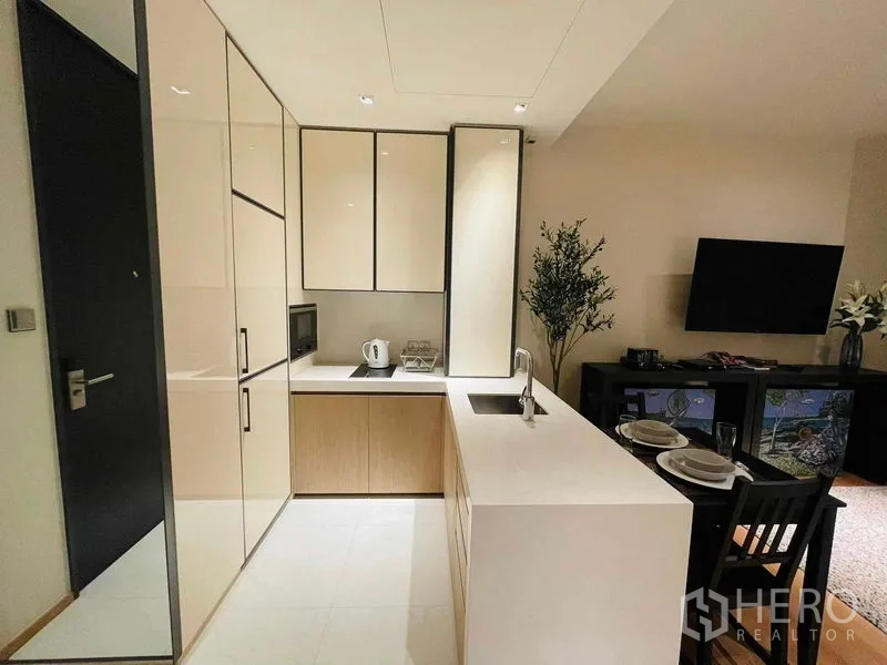 คอนโด ให้เช่าในKhlong Toei, Bangkok - ครัวรูปตัวแอลขนาดกะทัดรัด เคาน์เตอร์สีขาว เครื่องใช้บิวท์อินและอ่างล้างจาน