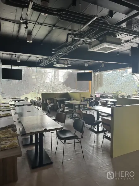 零售空间 出租在Khlong Toei, Bangkok - 开放式天花就餐区，外露管线、吊顶空调与多组餐桌。