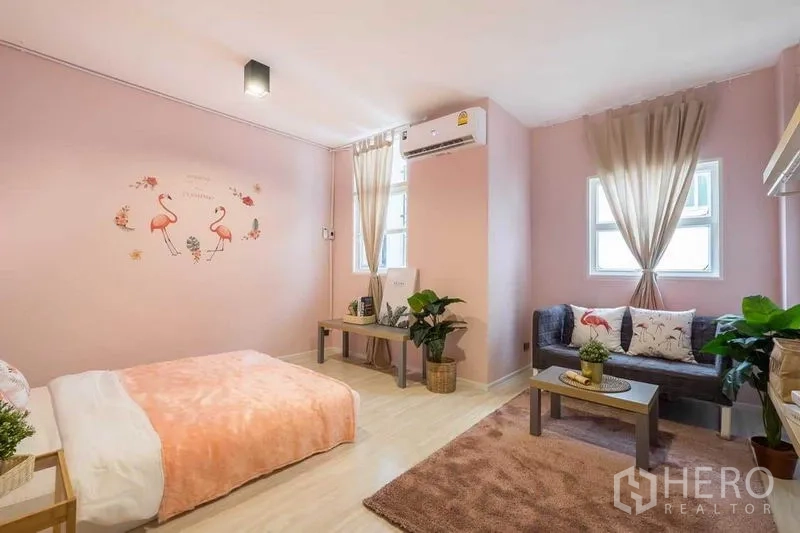 บ้าน ให้เช่าในKhlong Toei, Bangkok - ห้องนอนพาสเทลสีชมพู มีเตียง โซฟา เครื่องปรับอากาศ และหน้าต่างสองบาน