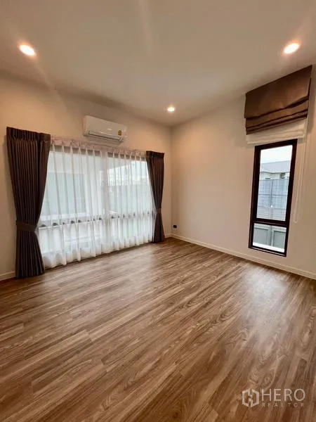 Detached House for rent in Bang Kapi, Bangkok - Multipurpose room with wood floors, sheer curtains and air conditioner.