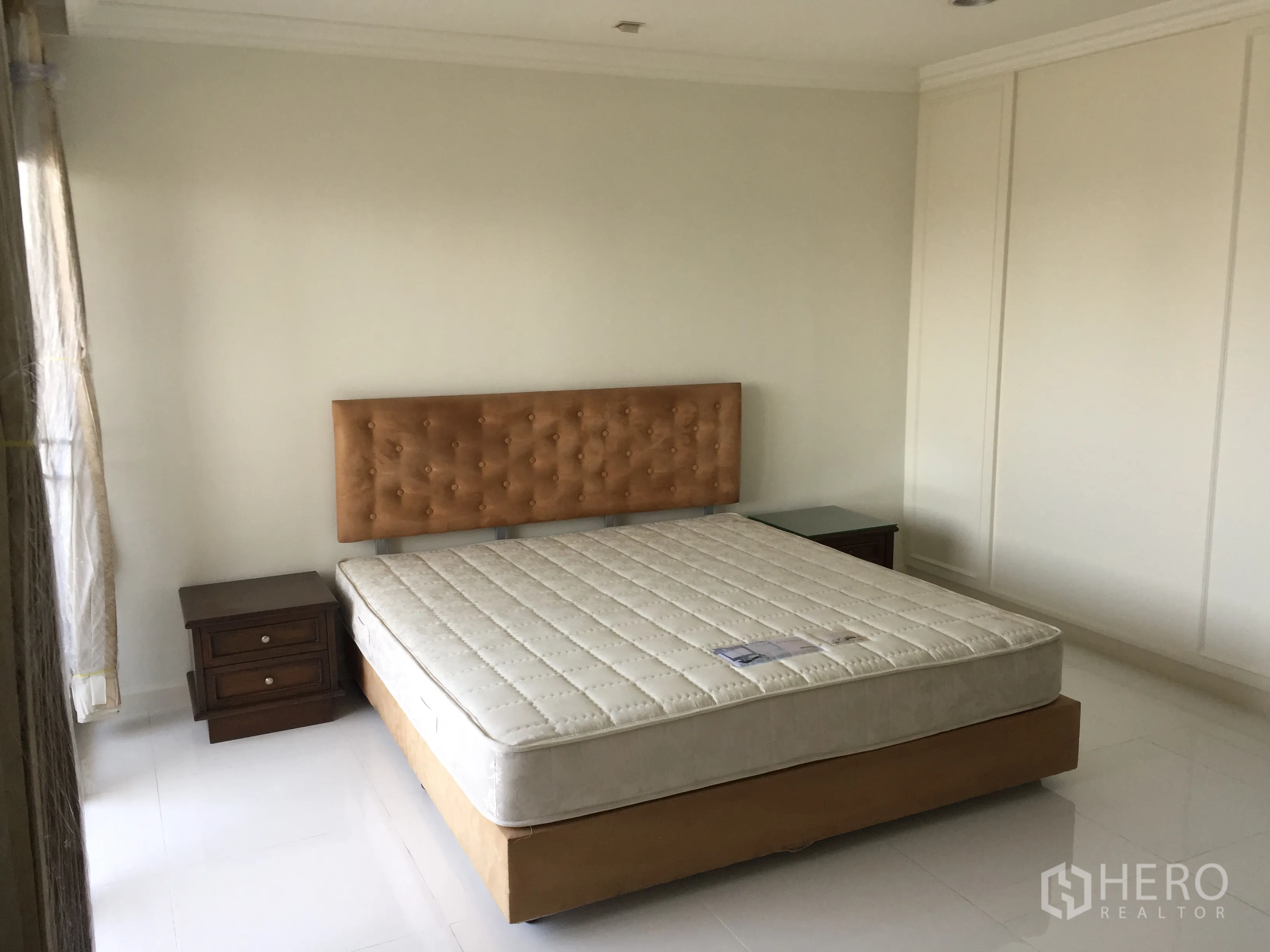 คอนโด ให้เช่าในWatthana, Bangkok - ห้องนอนสว่างพร้อมหัวเตียงบุผ้า โต๊ะข้างเตียง และตู้เสื้อผ้าบานสูงเต็มผนัง