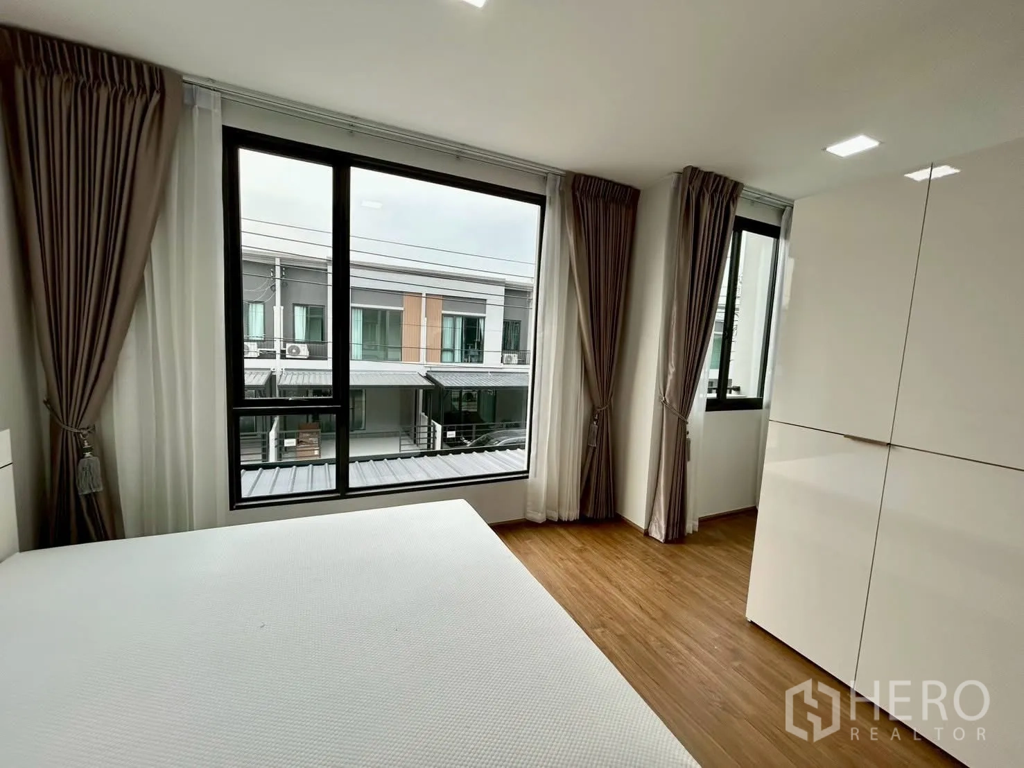 Townhouse for rent in Bang Phli, Samut Prakan - Corner bedroom with two large windows and tall wardrobe.