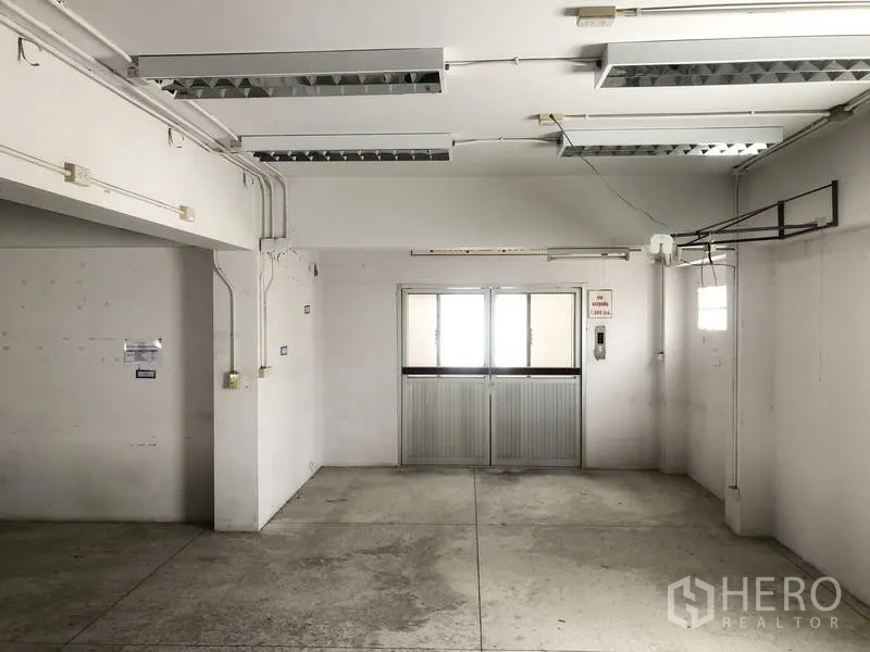 工厂 出租在Prawet, Bangkok - 工业房间，荧光灯照明、外露电力管线与推拉门