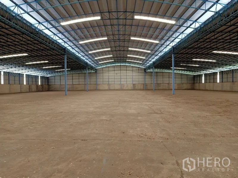 Factory for rent in Chaloem Phra Kiat, Saraburi - Expansive factory interior with high steel truss roof, skylights and open clear-span floor.