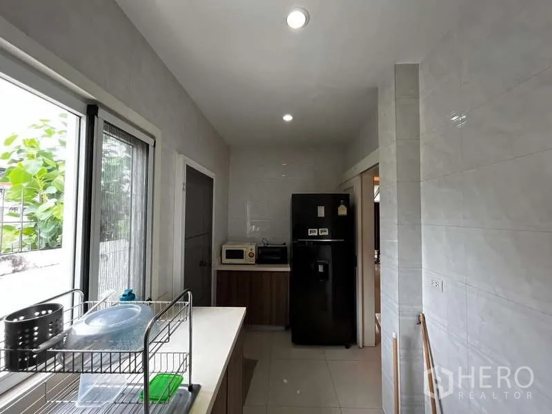 บ้าน ให้เช่าในPrawet, Bangkok - ครัวแบบแกลเลย์พร้อมหน้าต่าง ตู้เก็บของ และตู้เย็น.