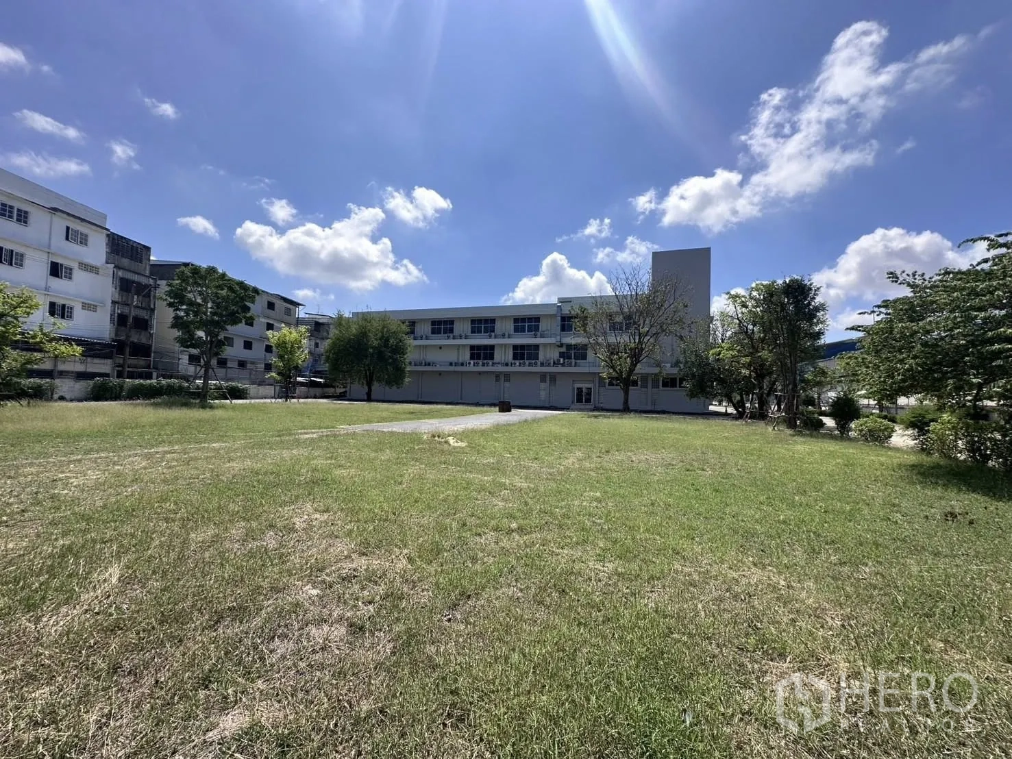 คลังสินค้า for rent in Mueang Samut Prakan, Samut Prakan - สนามหญ้าโล่งหน้าตึกสำนักงาน รายล้อมด้วยต้นไม้