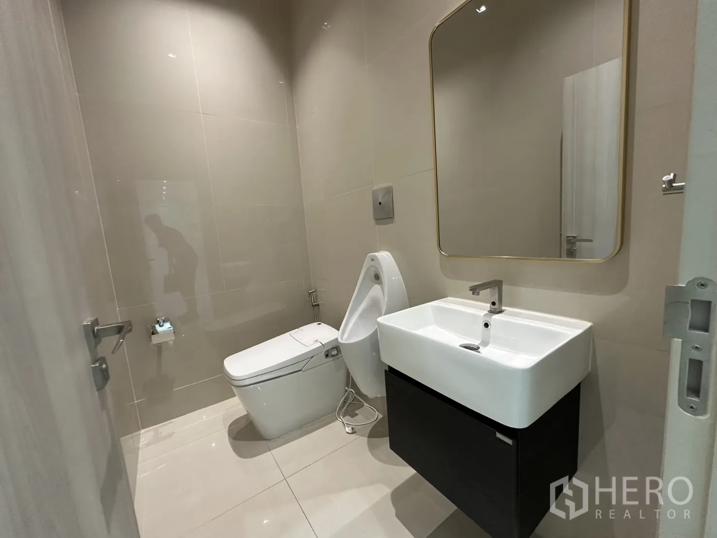 零售空间 出租 - 现代卫生间，带方形台盆、智能马桶与小便器。