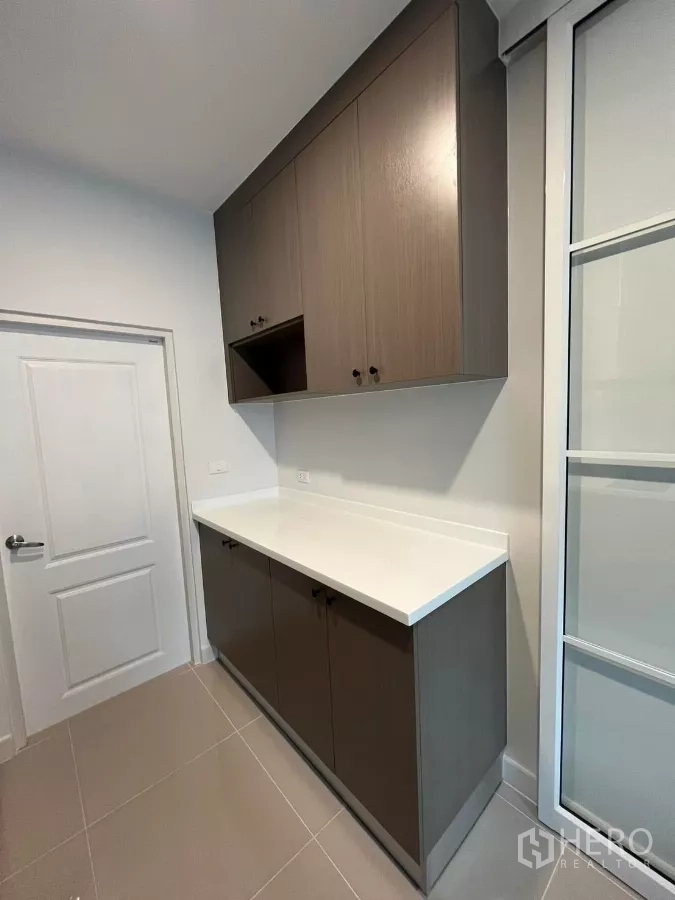 Detached House for rent or sale in Bang Phli, Samut Prakan - Pantry corridor with upper and lower cabinetry and a white countertop.