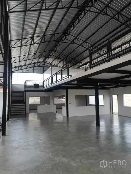 Factory for rent or sale in Mueang Samut Prakan, Samut Prakan - Open-plan warehouse floor with mezzanine office, stairway and exposed steel trusses.
