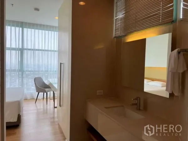 Condominium for rent in Bang Kho Laem, Bangkok - Vanity area leading to a bright bedroom with full-height windows.