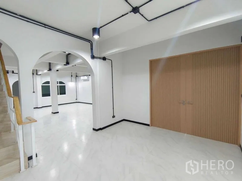 Townhouse for sale in Bang Phlat, Bangkok - Spacious ground floor with archways, staircase and large storage cabinet.