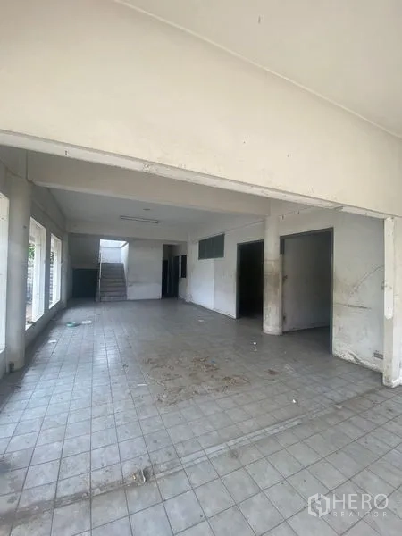Office Space for sale in Wang Thonglang, Bangkok - Ground-floor open hall with tiled floor and a rear staircase, ready for fit-out.