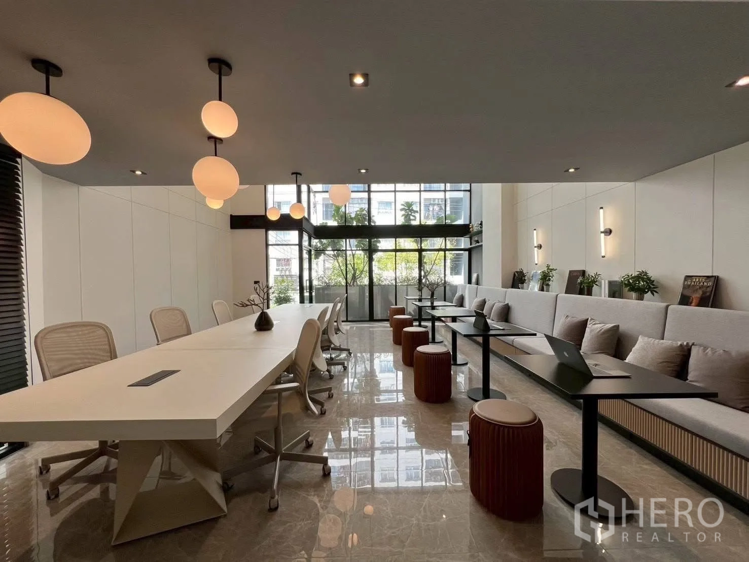 Home Office for rent or sale in Mueang Samut Prakan, Samut Prakan - Workspace with long tables, upholstered bench seating and floor-to-ceiling glass.