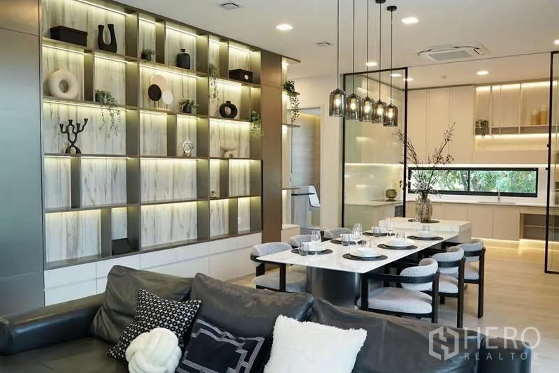 Detached House for rent in Saphan Sung, Bangkok - Dining area with marble table, pendant lights and an illuminated display wall.