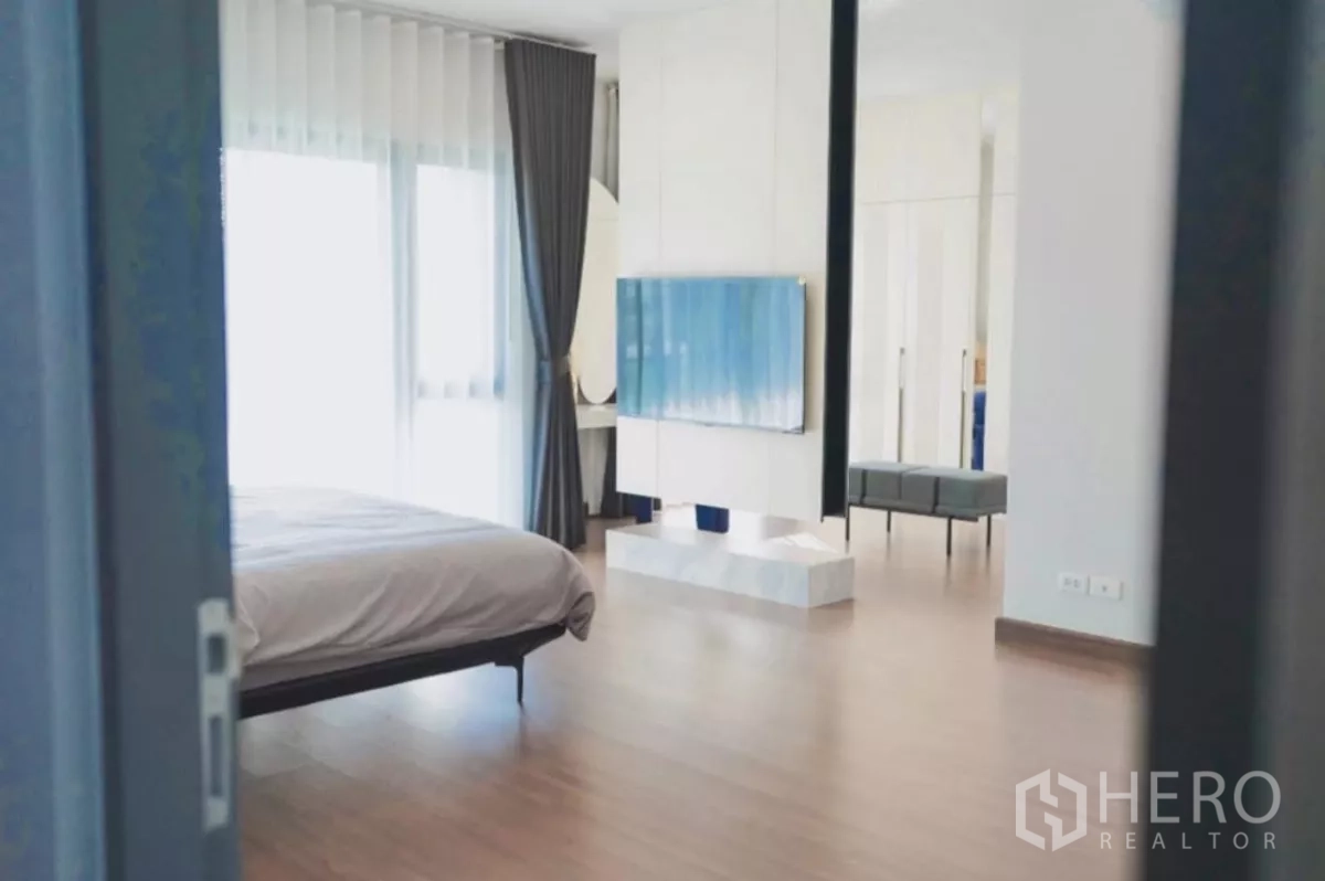 独立式住宅 出租在Bang Phli, Samut Prakan - 主卧概览，电视隔断与休闲区、木地板。