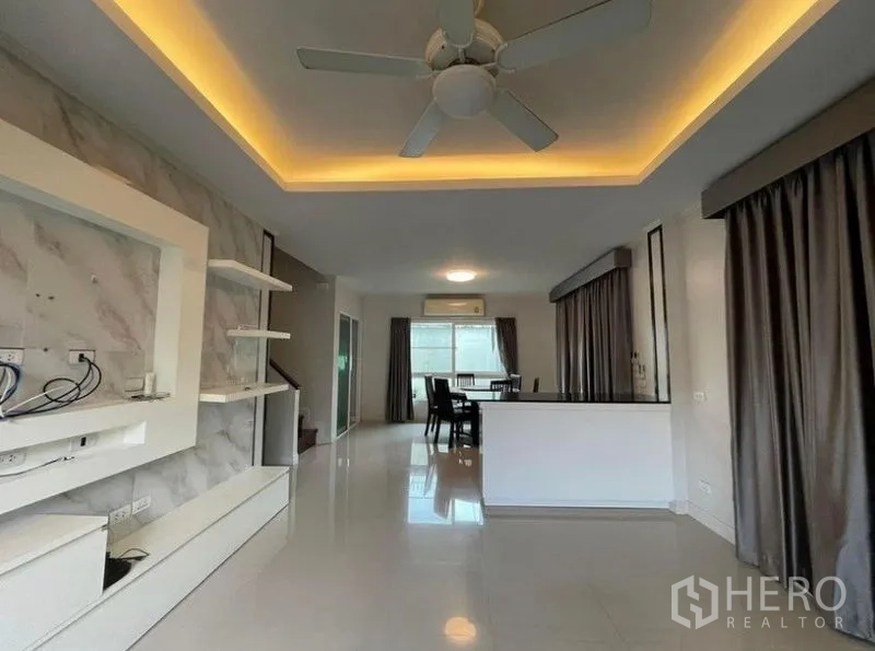 独立式住宅 出售在Bang Phli, Samut Prakan - 开放式客厅，筒灯、吊扇、内置层架与亮面地坪。