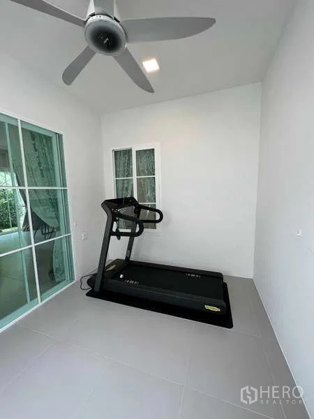 Detached House for sale in Bang Phli, Samut Prakan - Small fitness room with treadmill and ceiling fan next to glass door