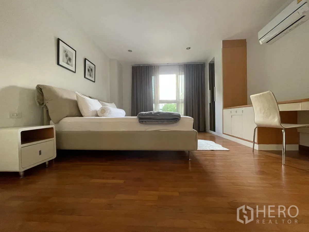 Condominium for rent in Watthana, Bangkok - Bedroom with built-in desk, wardrobe and wide window with curtains.
