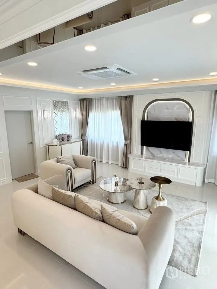 Detached House for rent in Bang Phli, Samut Prakan - Lounge with sofa set, TV on marble feature wall and round nesting tables.