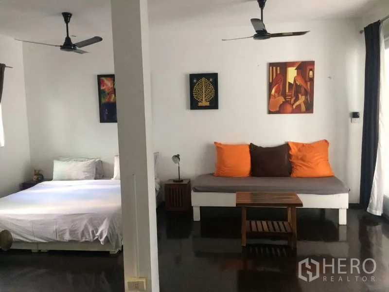 บ้าน ให้เช่าในSathon, Bangkok - พื้นที่พักอาศัยกว้าง มีเตียง โซฟาเดย์เบด พัดลมเพดาน และงานศิลป์ติดผนัง