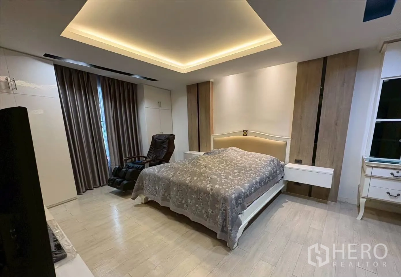 联排别墅 for rent in Pathum Wan, Bangkok - 主卧设灯带吊顶、床、按摩椅与床头柜。
