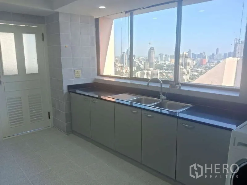 คอนโด ให้เช่าในKhlong Toei, Bangkok - ครัวปิดสว่าง เคาน์เตอร์หินสีดำยาว อ่างล้างจานคู่ พร้อมวิวสกายไลน์กรุงเทพฯ ที่ President Park