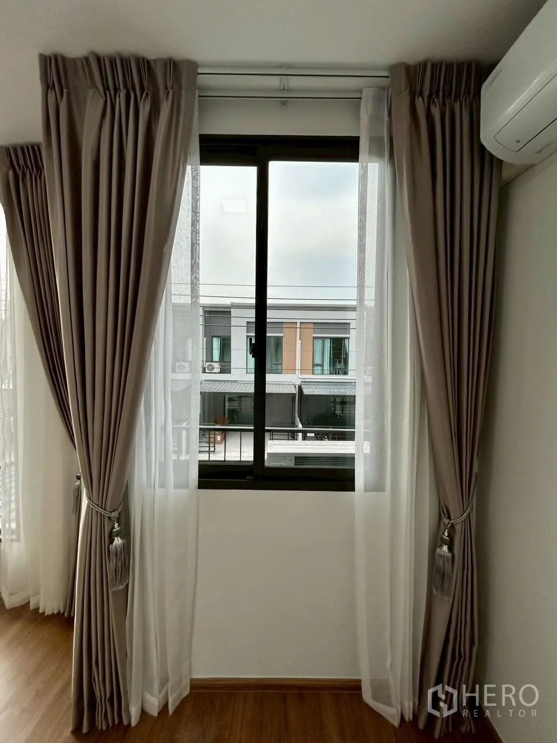 Townhouse for rent in Bang Phli, Samut Prakan - Close-up of curtained window with view of opposite homes.