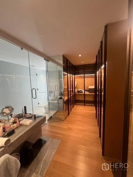 Townhouse for rent - Walk-in closet corridor with glass shower enclosure and vanity along wood flooring