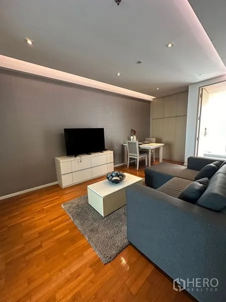 อพาร์ทเมนท์ ให้เช่าในKhlong Toei, Bangkok - ห้องนั่งเล่นอบอุ่น โซฟา พรม ตู้ทีวี และมุมรับประทานอาหาร