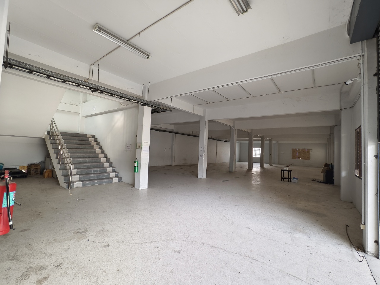 Warehouse for rent in Lat Krabang, Bangkok - Spacious ground-floor warehouse bay with high ceilings, columns, and a stairwell.