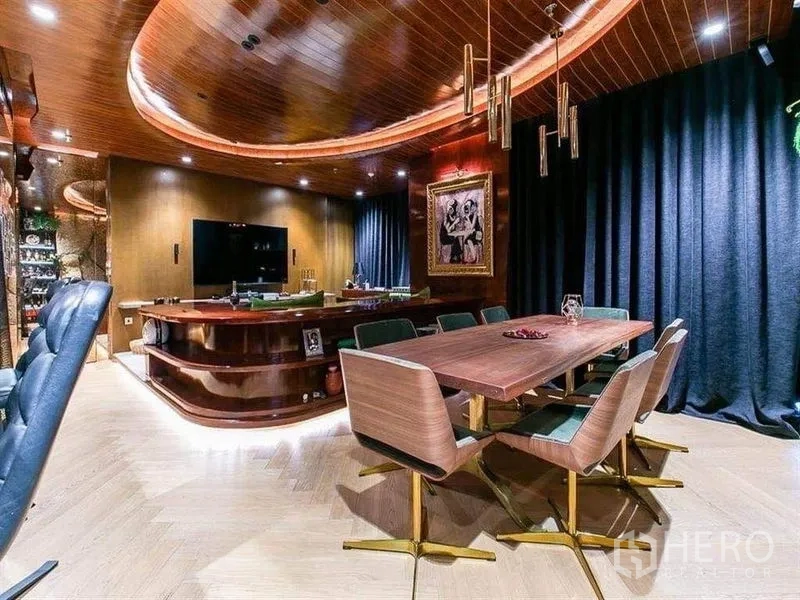 公寓 出租在Watthana, Bangkok - 明亮餐客区，长木桌、设计感吊灯与弧形娱乐吧台