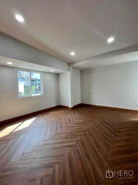 ทาวน์เฮาส์ ขายในPhra Khanong, Bangkok - ห้องนั่งเล่นโล่งพื้นลายไม้ก้างปลา พร้อมไฟดาวน์ไลท์