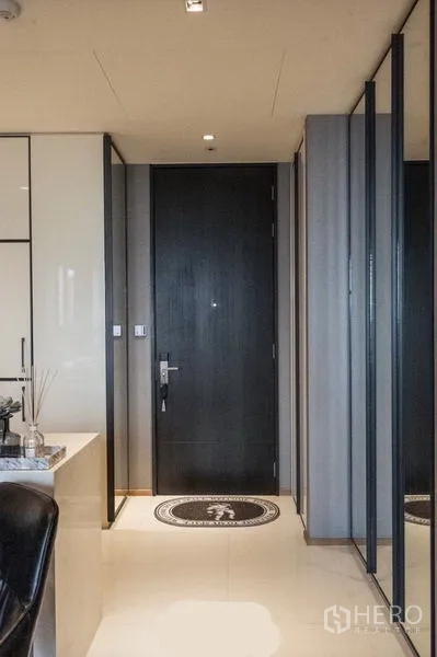 公寓 出租在Khlong Toei, Bangkok - 入户玄关，黑色大门、镜面衣柜与浅色地砖。