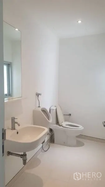 带办公室的家 出租在Phra Khanong, Bangkok - 极简白色卫浴，马桶、挂墙式洗手盆与窗口。